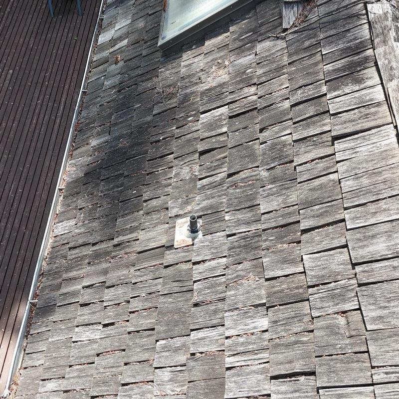 Wood shingle roof with vent pipe and weathering damage