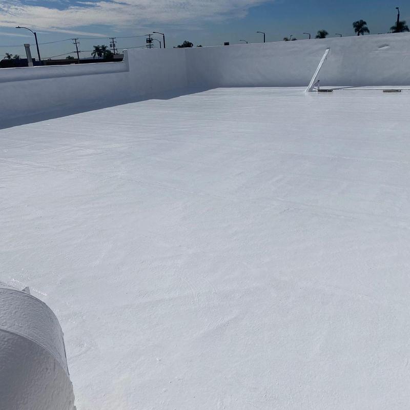 Flat roof silicone coating on commercial building Flat roof silicone coating on commercial building