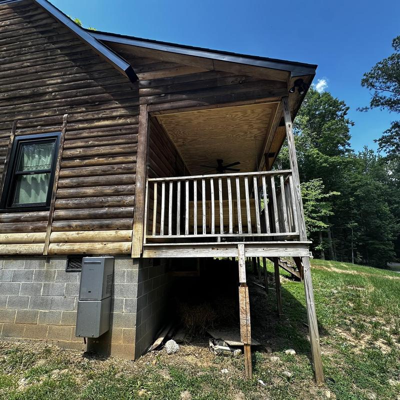 Wooden porch structure with railing and support posts