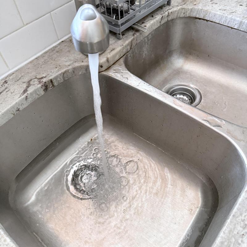 Kitchen sink drains with running faucet water Kitchen sink drains with running faucet water