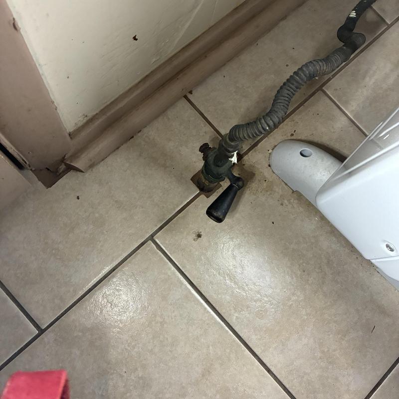 Gas shutoff valve and flexible piping on tiled floor Gas shutoff valve and flexible piping on tiled floor