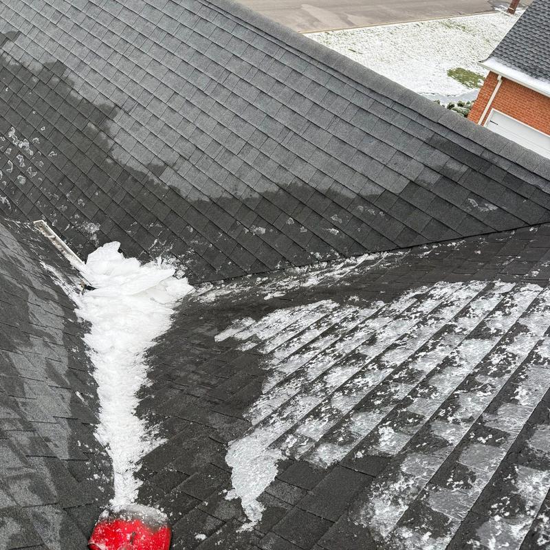 Roof shingles with hail damage and snow accumulation