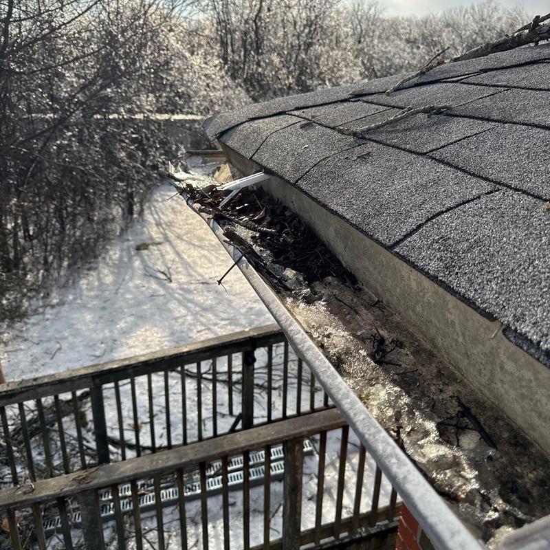 Roof gutter clogged with debris and frozen buildup