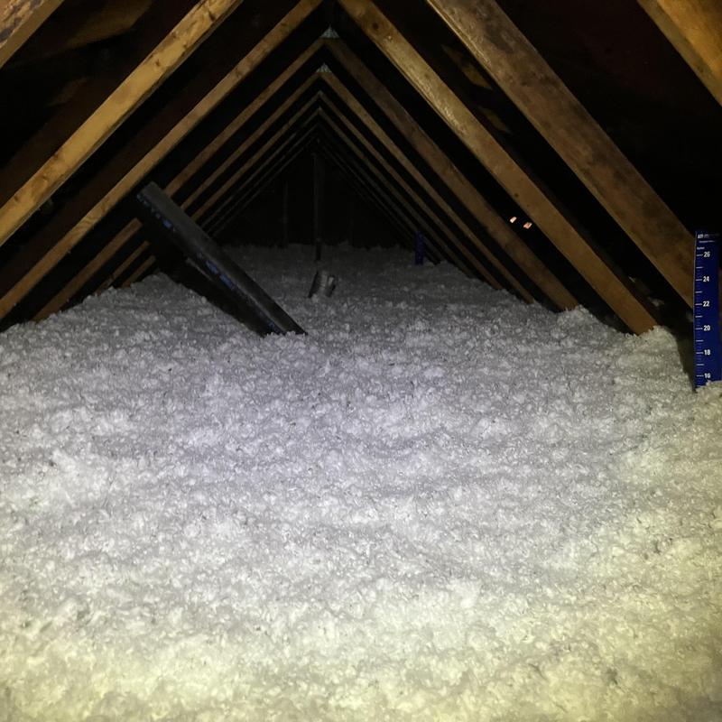 Attic blown-in insulation covering floor joists