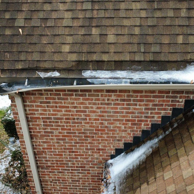 Asphalt shingles and metal flashing with ice buildup on roof