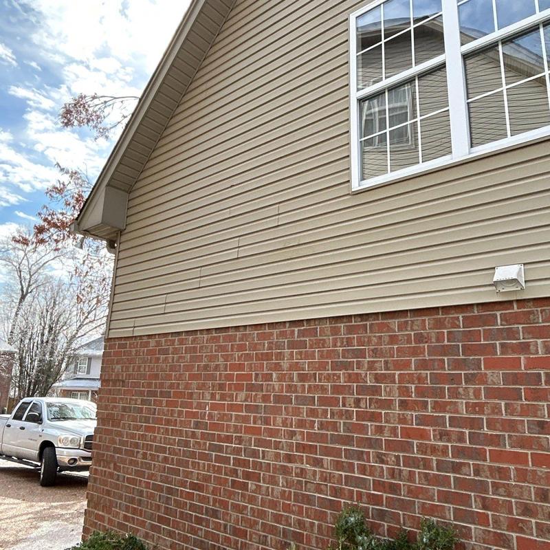 Vinyl siding damage inspection on residential home exterior