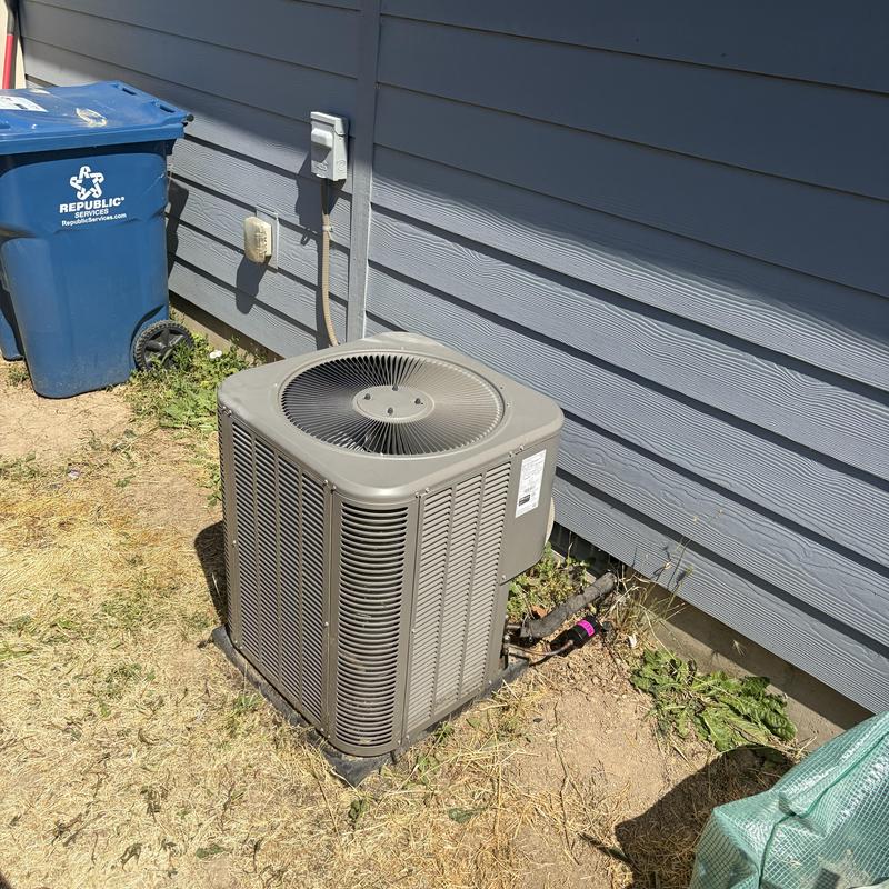 AC outdoor coil unit beside house exterior wall
