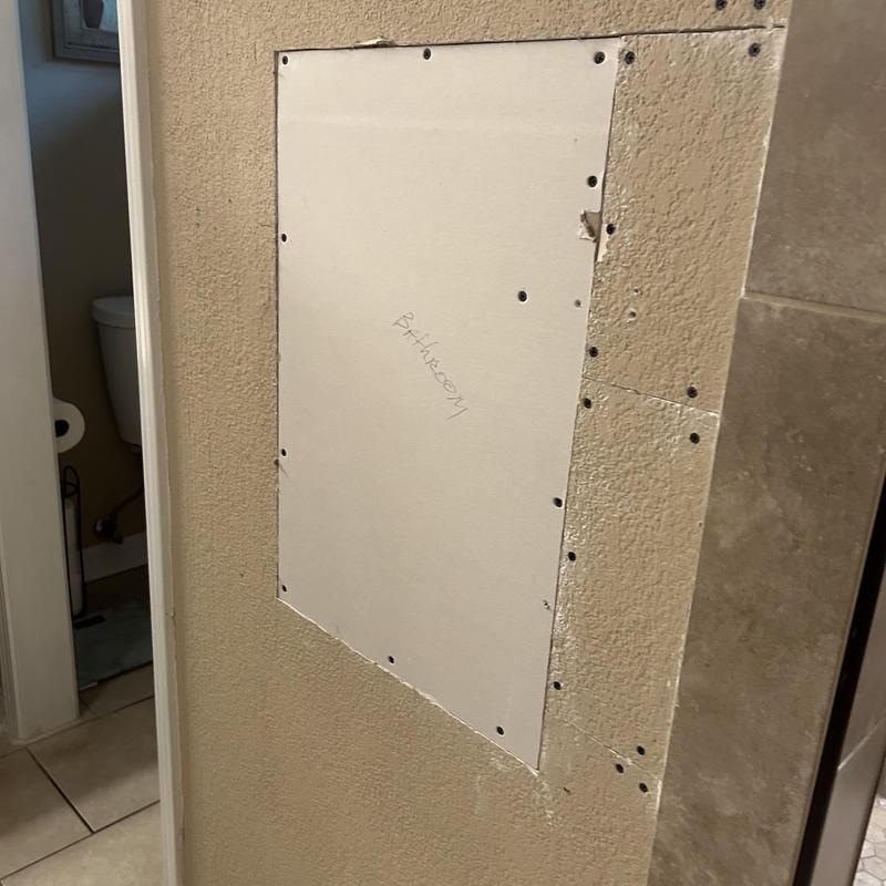 Drywall patch installed in bathroom wall access panel Drywall patch installed in bathroom wall access panel
