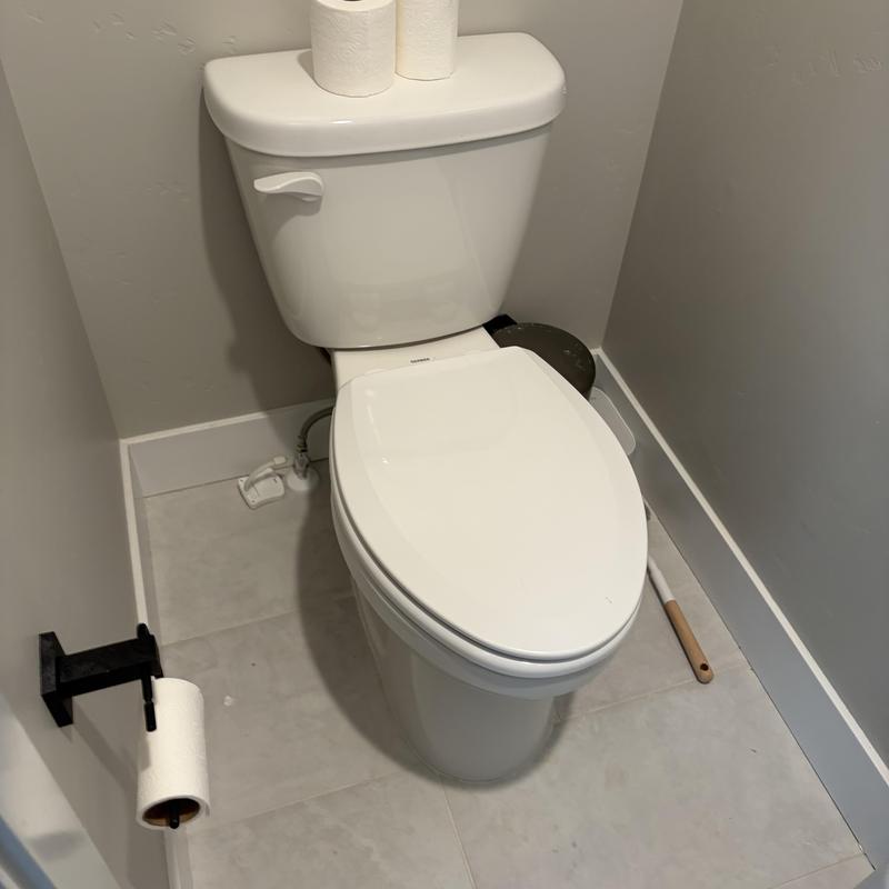 Toilet with replaced wax seal and reset in bathroom