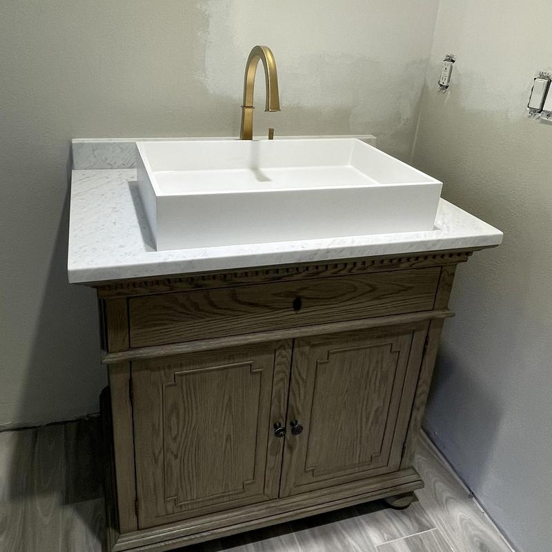 Bathroom vanity countertop with sink and gold faucet