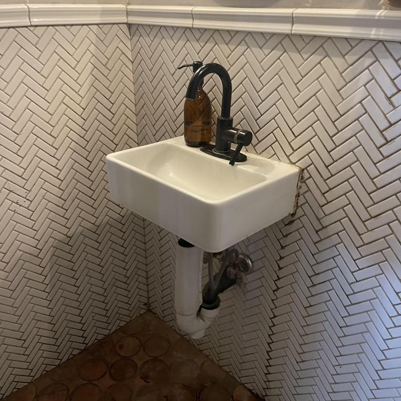 Proflo wall-mounted sink with black faucet installation