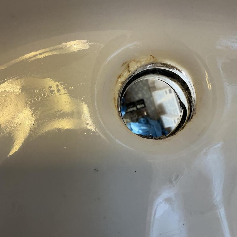 Lavatory sink drain hole with rust and residue buildup