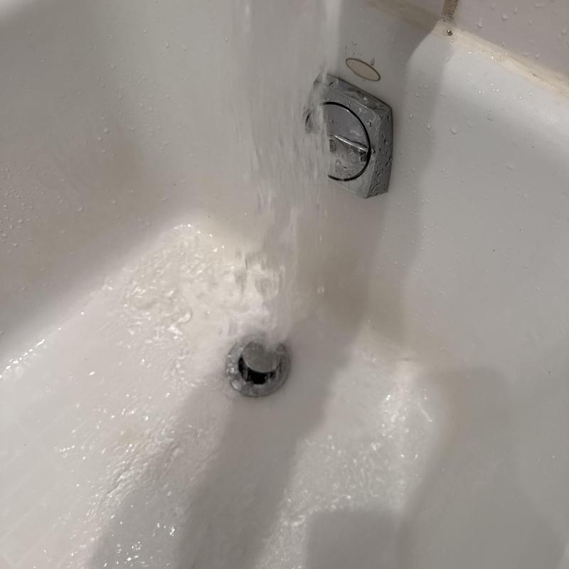 Bathtub drain with flowing water after cleaning