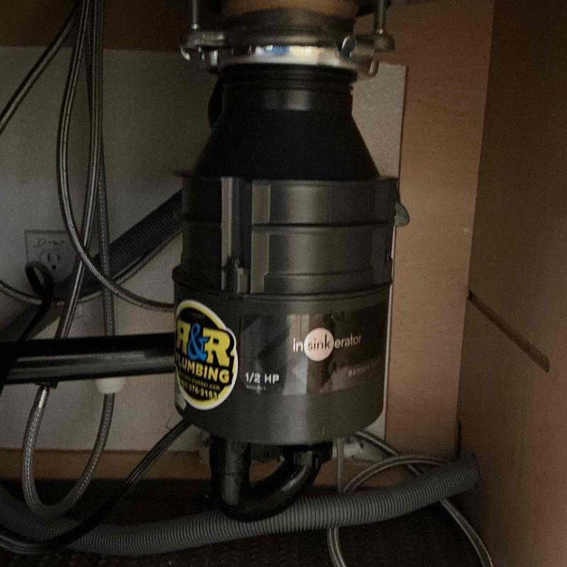 Garbage disposal unit with plumbing connections under sink