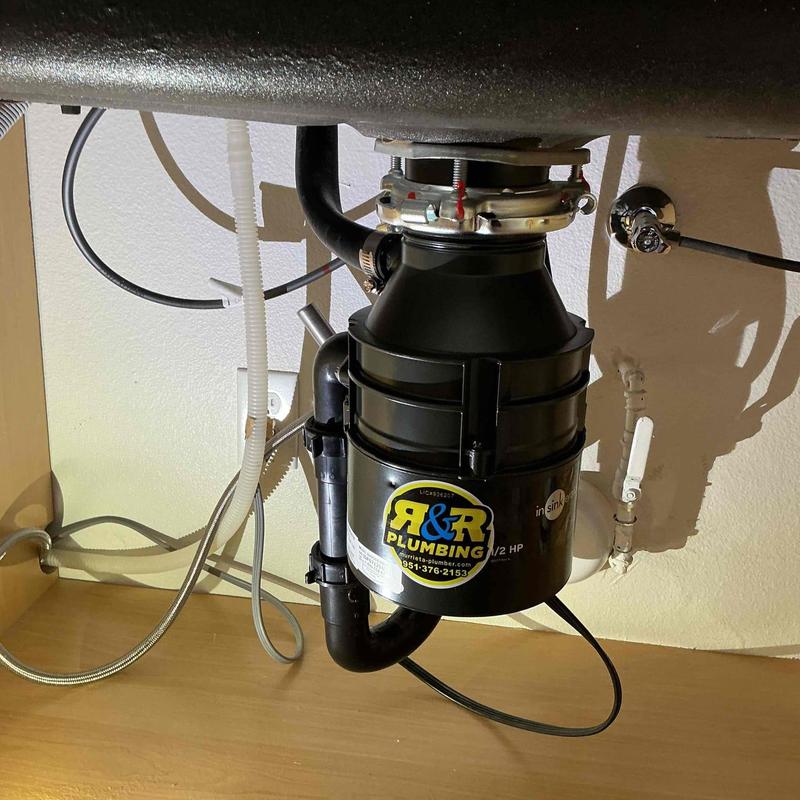 Garbage disposal unit with plumbing connections under sink