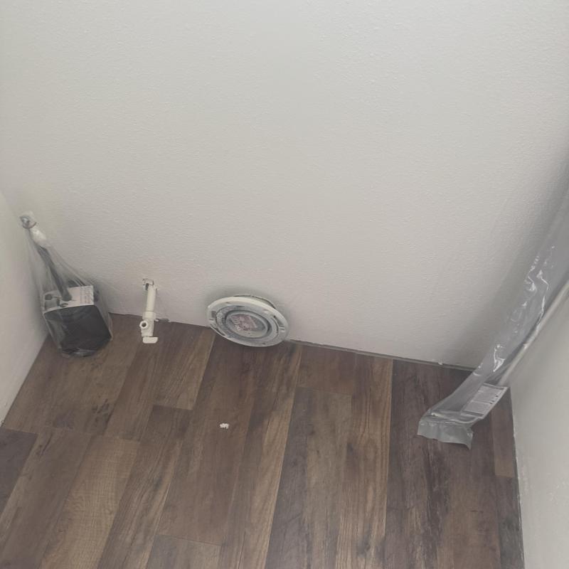 Wall-mounted toilet plumbing rough-in on wood floor