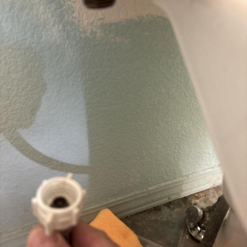 Toilet supply line connection with hand near valve