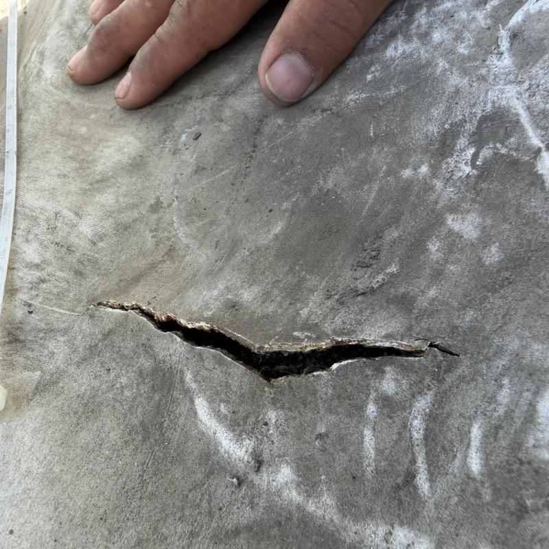 Roof underlayment tear with hand for scale Roof underlayment tear with hand for scale