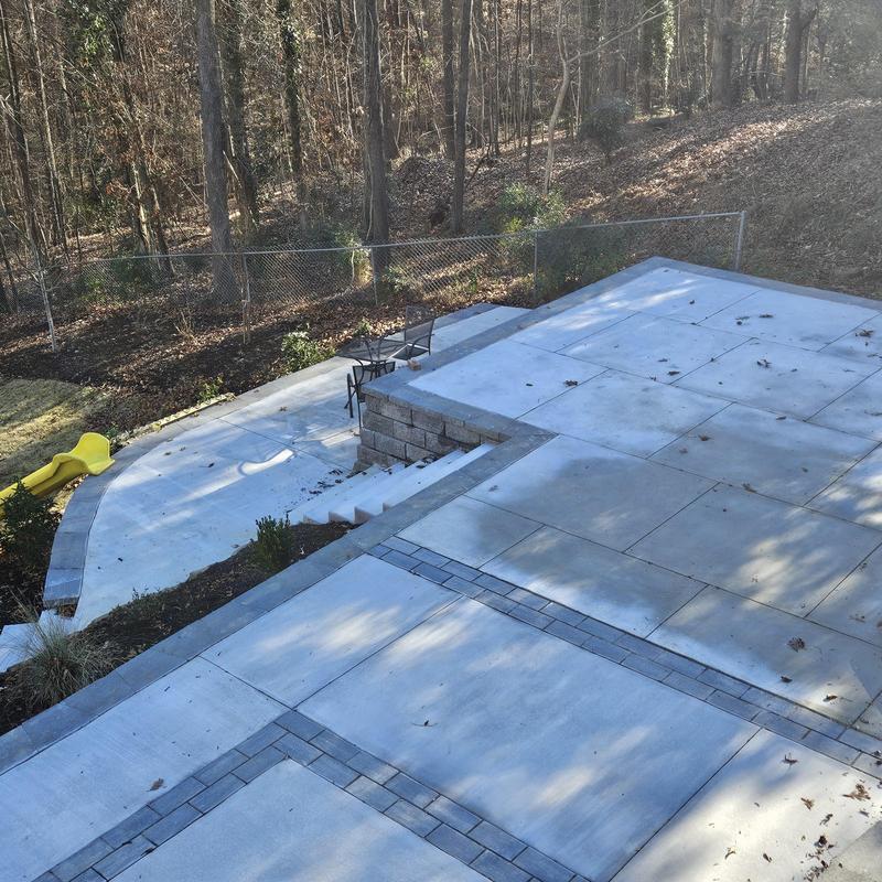 Concrete patio with stone border and retaining wall Concrete patio with stone border and retaining wall