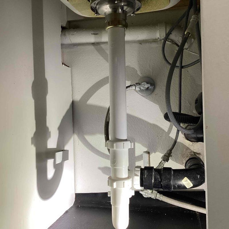 Tubular drain and basket strainer under kitchen sink