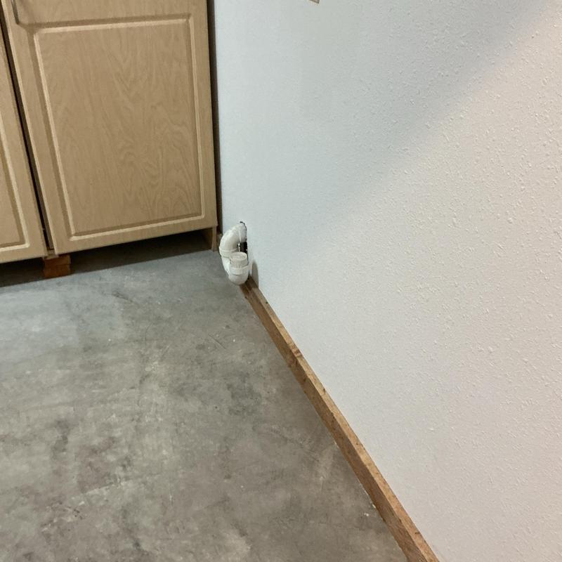 PVC drain pipe by wall near cabinet in basement