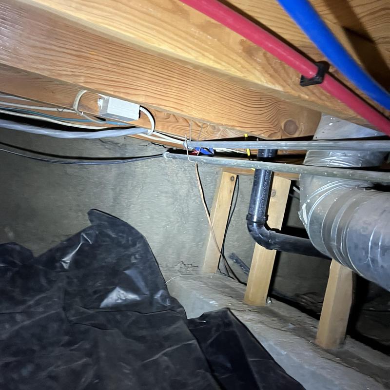PEX water piping installation under wooden floor joists