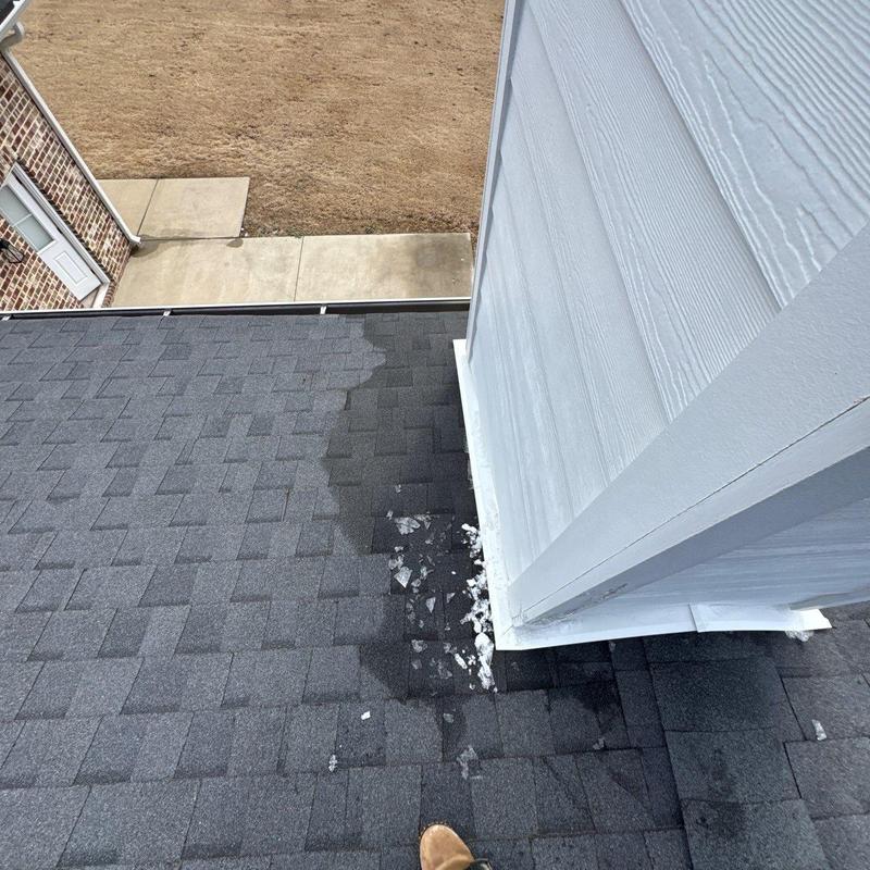Roof shingles with hail damage near chimney base
