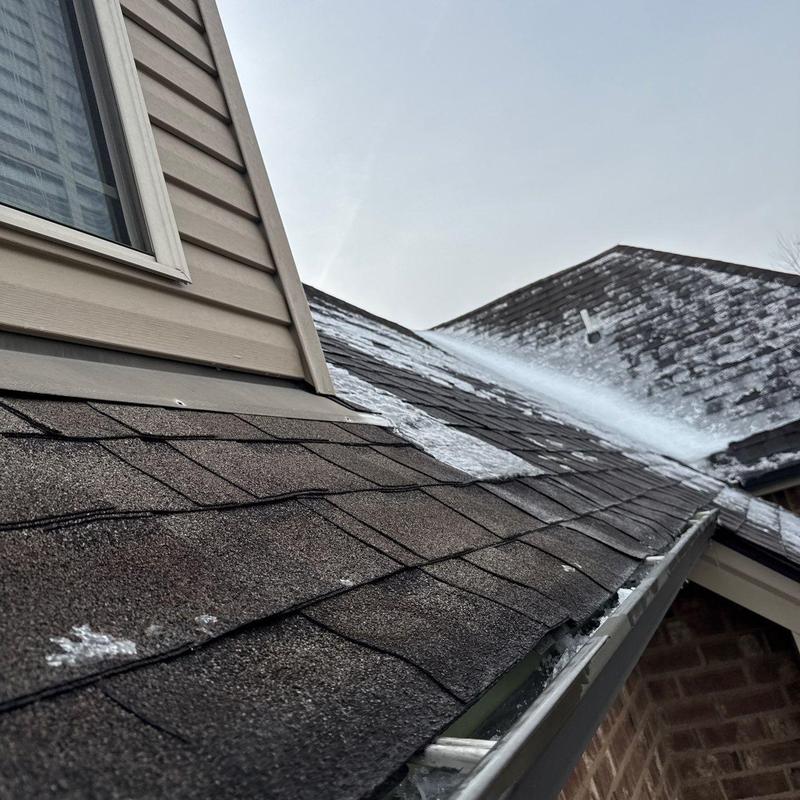 Roof shingles damaged by hail near roof flashing