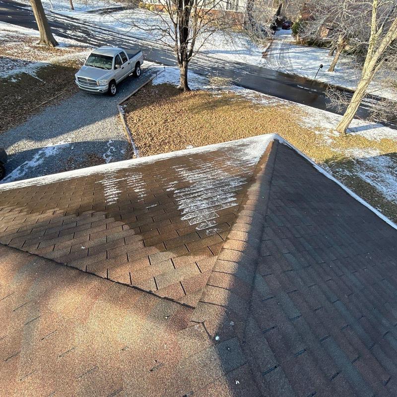 Asphalt shingles with hail damage and snow patches