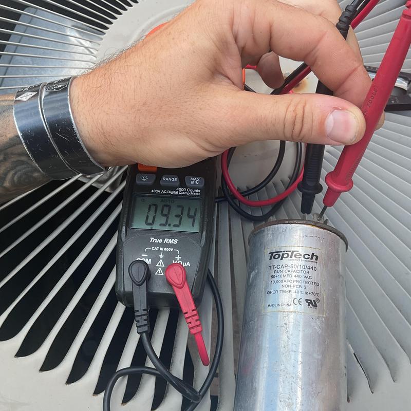 HVAC capacitor testing with digital multimeter on unit fan