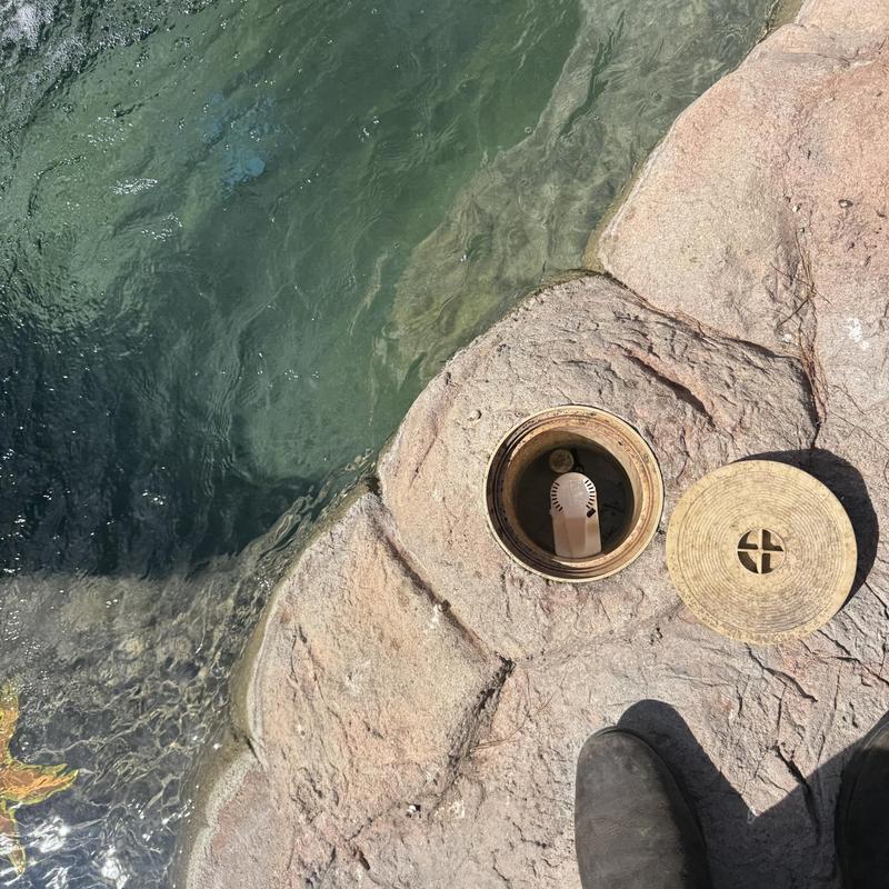 Pool skimmer valve and cover on stone deck