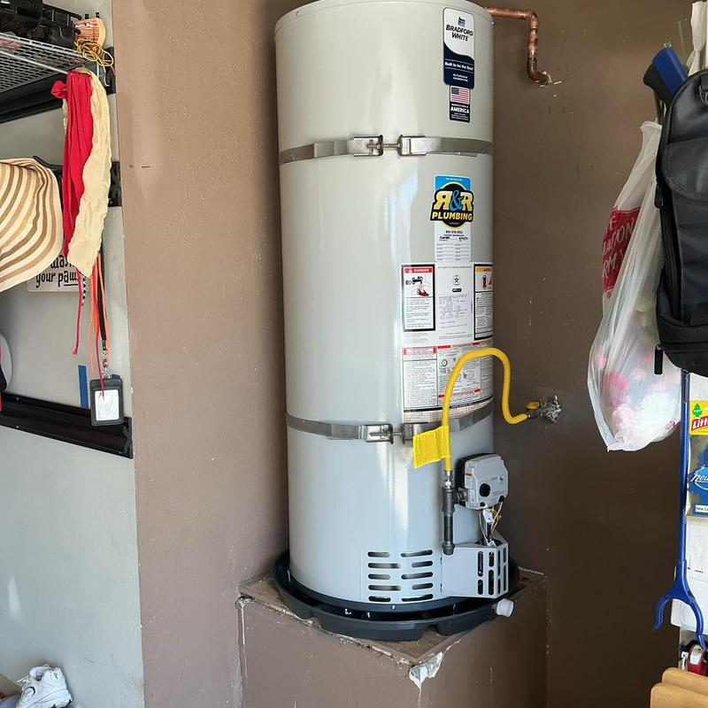 Gas water heater with sediment trap and drain pan