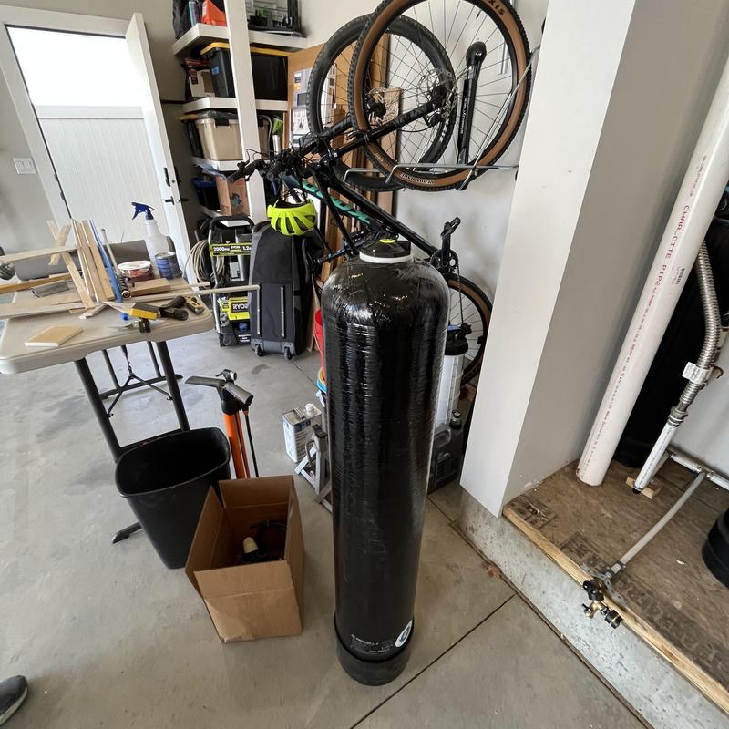 Water softener tank wrapped in protective plastic in garage