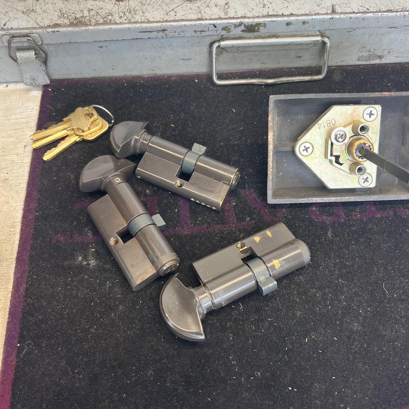 Profile cylinders and keys on workbench with tools
