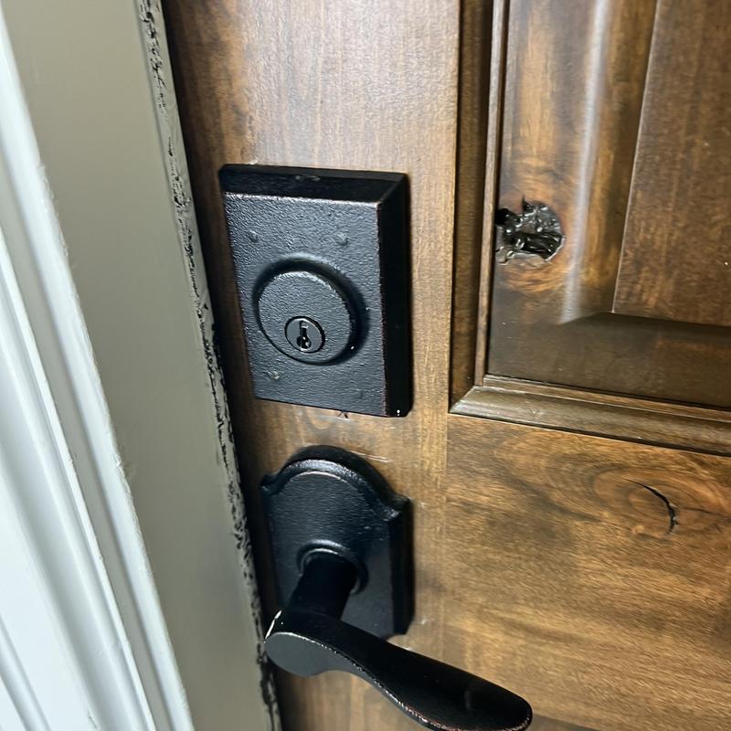 Deadbolt lock and door handle on wood door