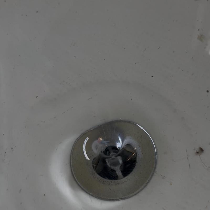 Tub drain with minor debris and dirt buildup Tub drain with minor debris and dirt buildup