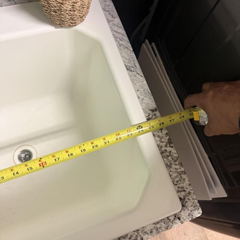 Drop-in kitchen sink with measuring tape on countertop