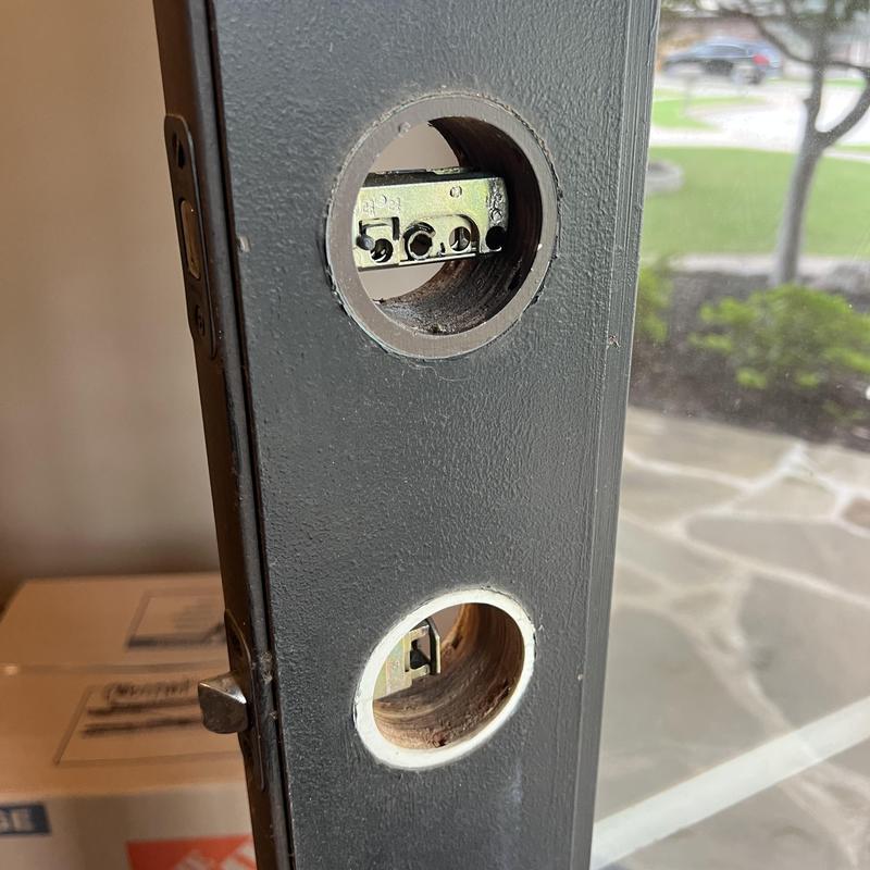 Door lockset with cylinder holes for rekeying