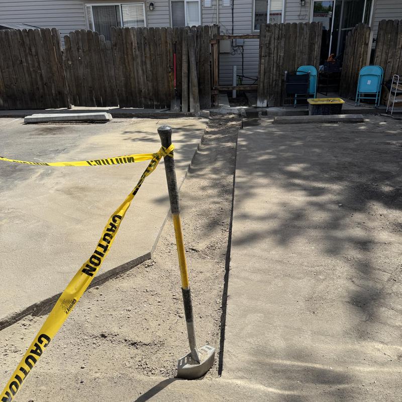 Sewer line trench with caution tape and shovel