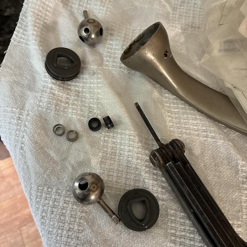 Kitchen faucet parts and tool on white towel