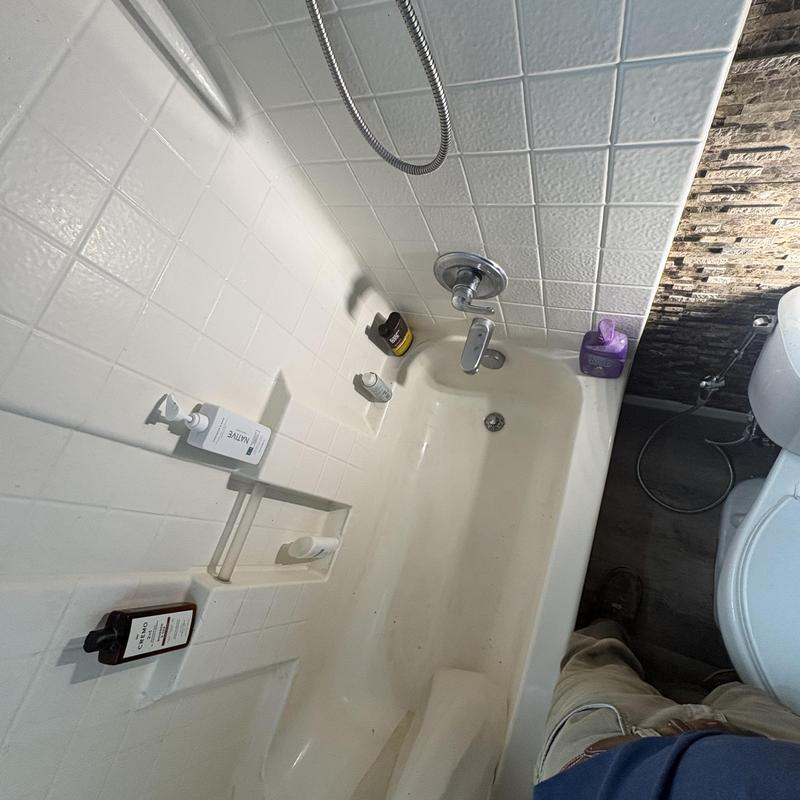 Bathtub faucet and showerhead in bathroom corner