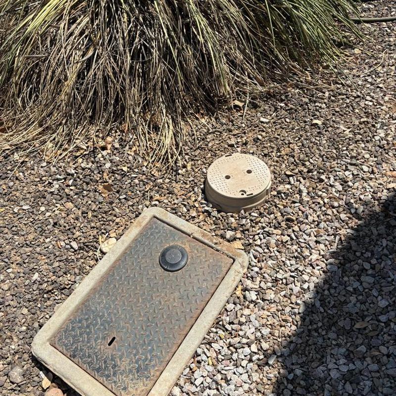Pressure relief valve access box and cover on gravel ground