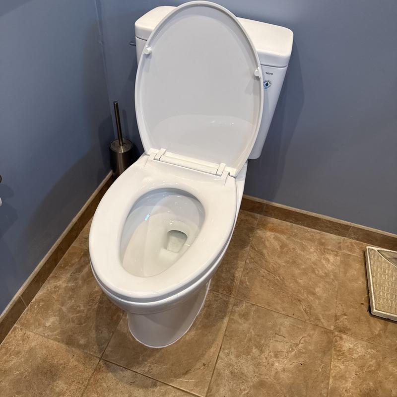 Toilet bowl and tank installation in bathroom corner