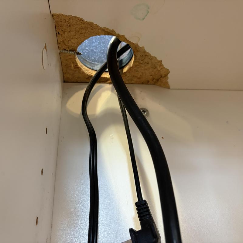 Electrical cords through water-damaged cabinet hole