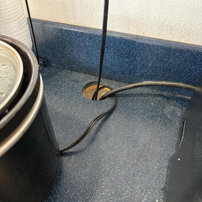 Electrical cords routed through countertop hole under cabinet