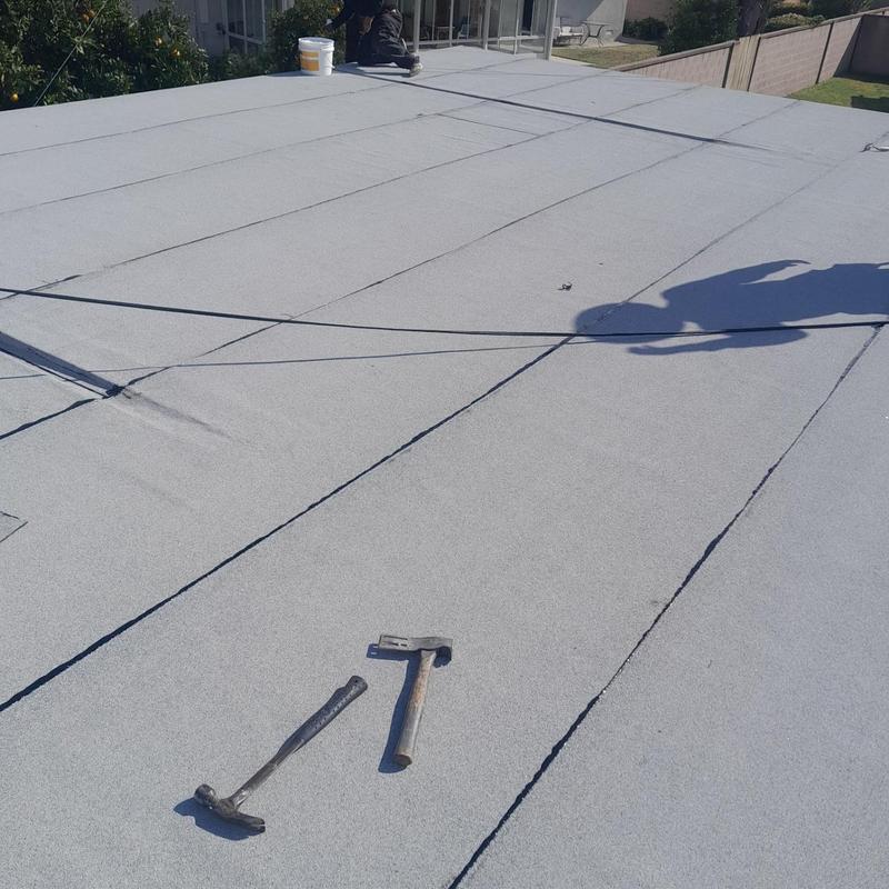 Flat roofing membrane installation with tools and worker shadow Flat roofing membrane installation with tools and worker shadow