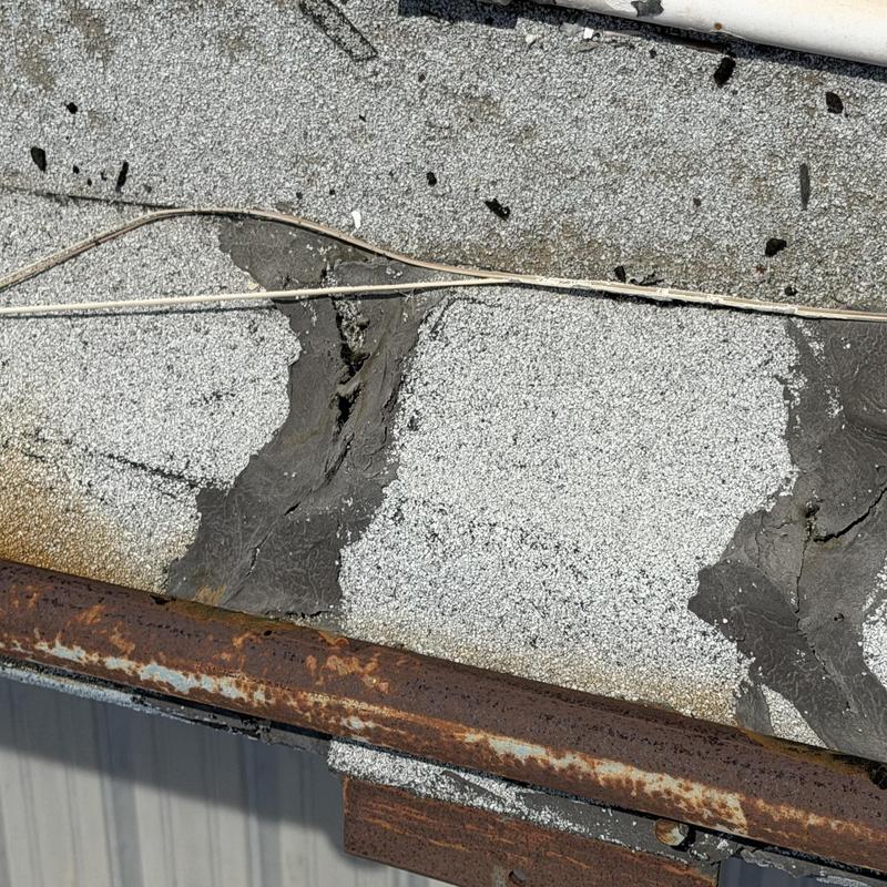 Roofing membrane with patched cracks and rusted metal edge Roofing membrane with patched cracks and rusted metal edge