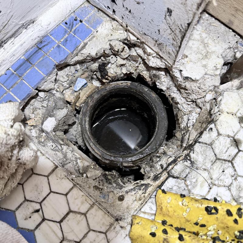 Tub drain pipe with surrounding broken tile and debris Tub drain pipe with surrounding broken tile and debris