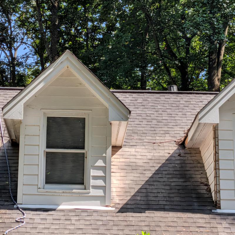 Dormer corner boards on roof with visible damage