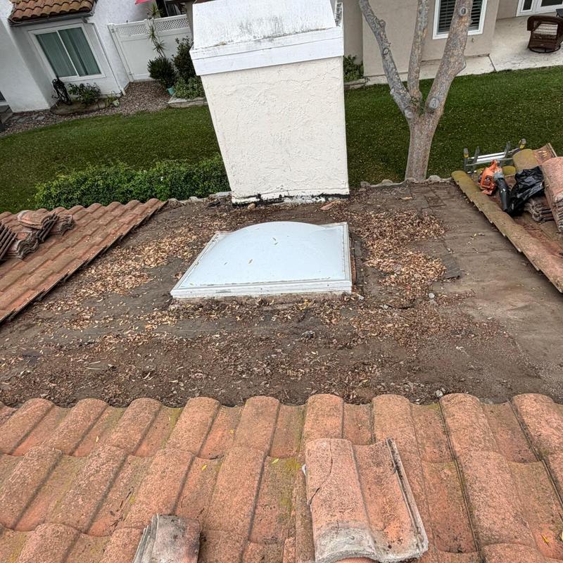 Tile roof section with removed tiles around skylight Tile roof section with removed tiles around skylight